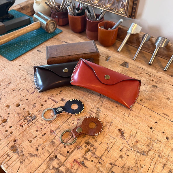 Leren AirTags en brillenkokers op werkbank uit de workshop leren accessoires maken