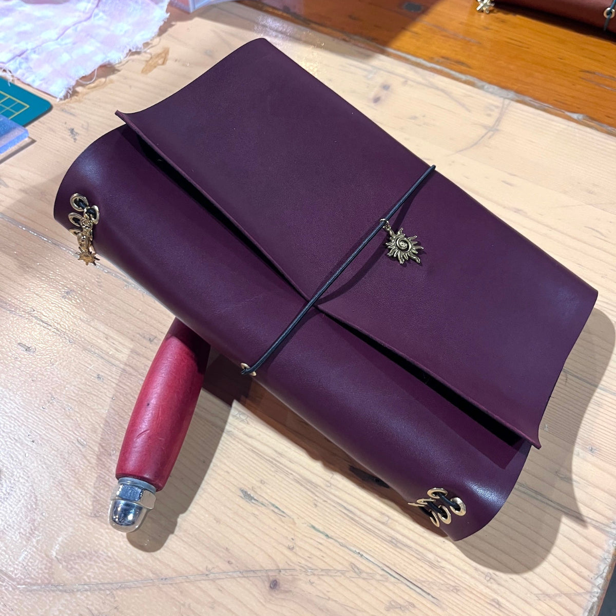 Eindresultaat van leren notebook in bordeaux met kralen op locatie