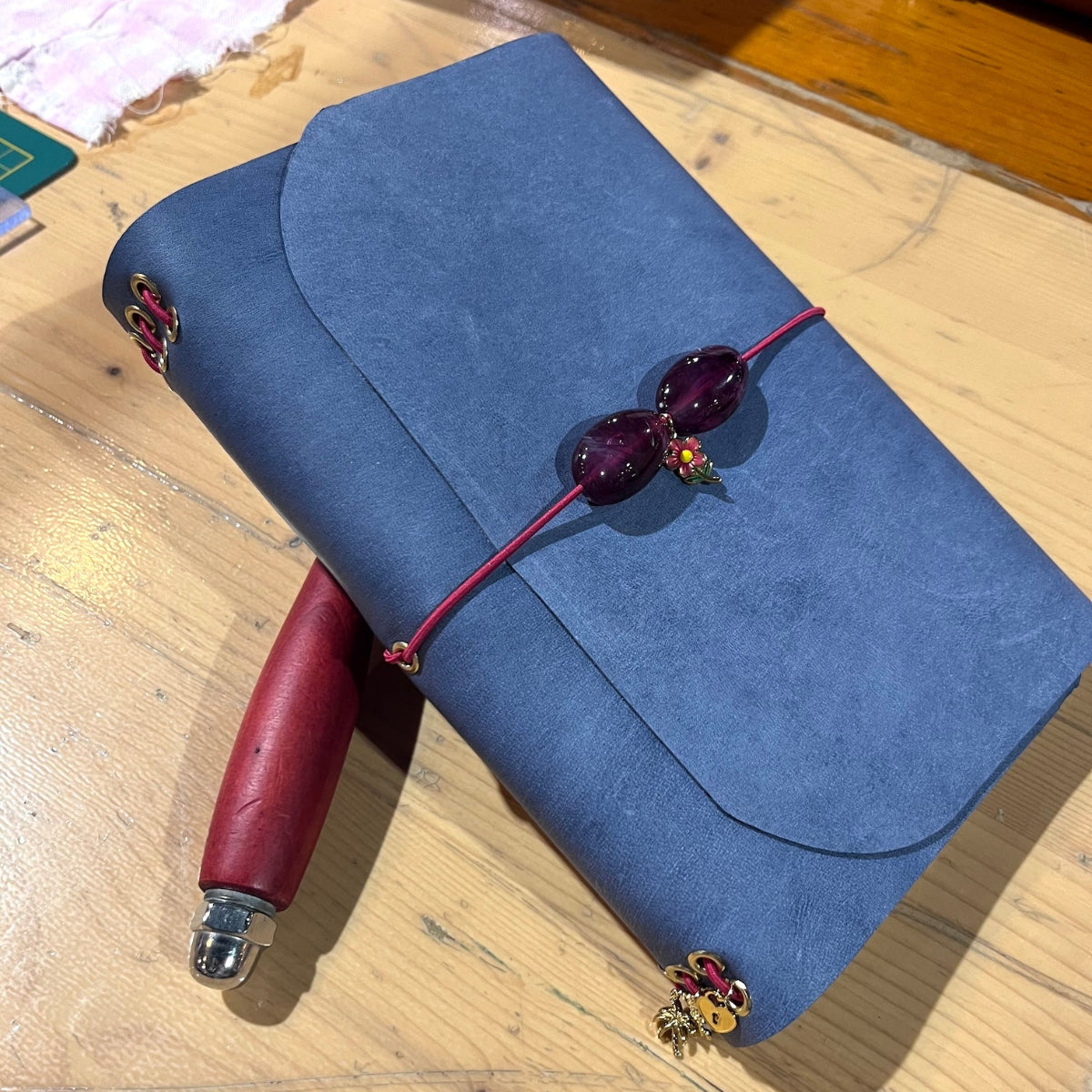Eindresultaat van leren notebook in blauw met kralen op locatie