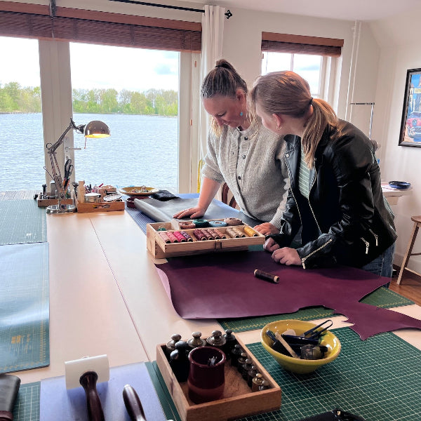 Overleg over garen in de workshop leren notebook cover maken