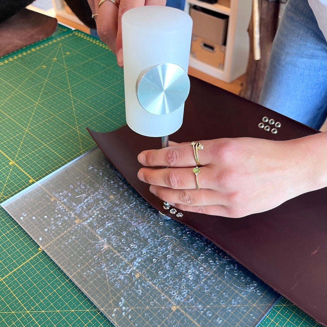 Workshop leren notebooks maakproces met hamer en leer