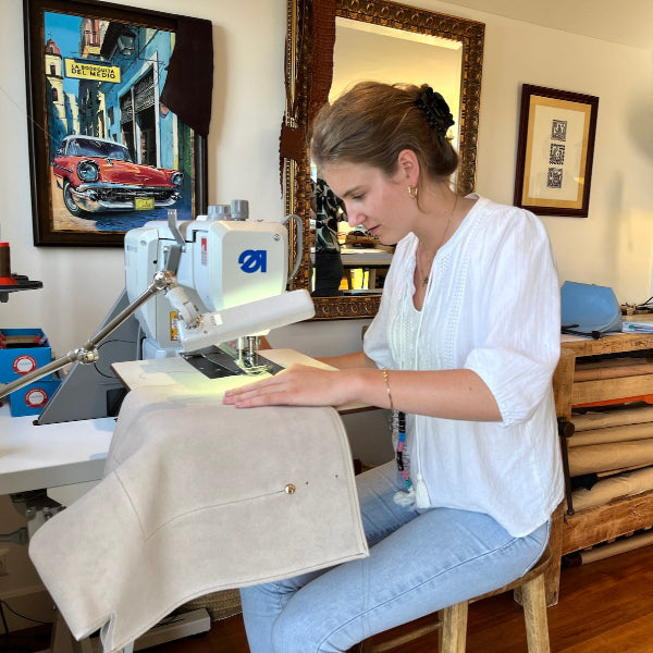 Achter de naaimachine voor het naaien van een leren shopper