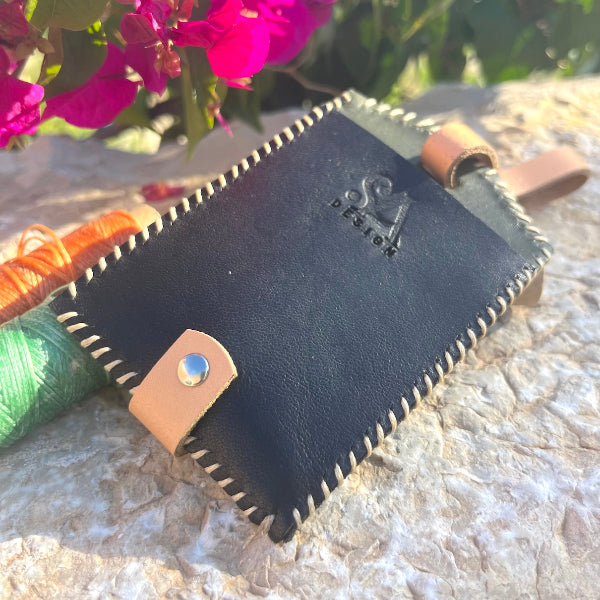 Close up van zwart bagagelabel met mooie stiksels in contrastkleur