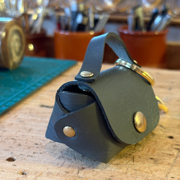 Bag charm in grijs op werkbank