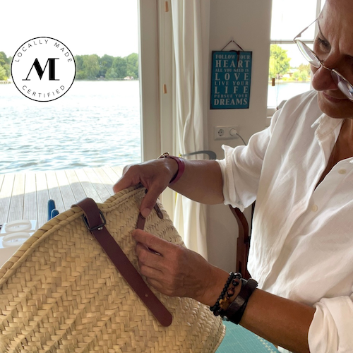 Nina die werkt aan een rieten tas in het atelier van SA Design