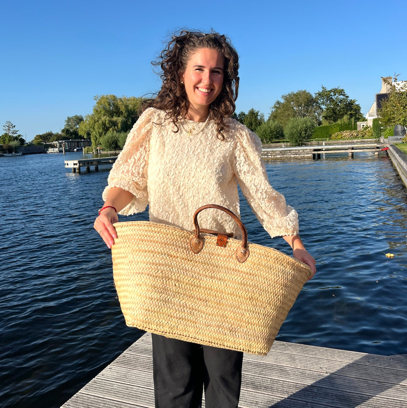 Sofia met een zeer grote rechthoekige rieten tas uit de Valencia collectie in de hand