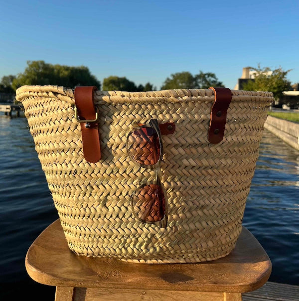 Handgemaakte rieten tas met zonnebril in de lus