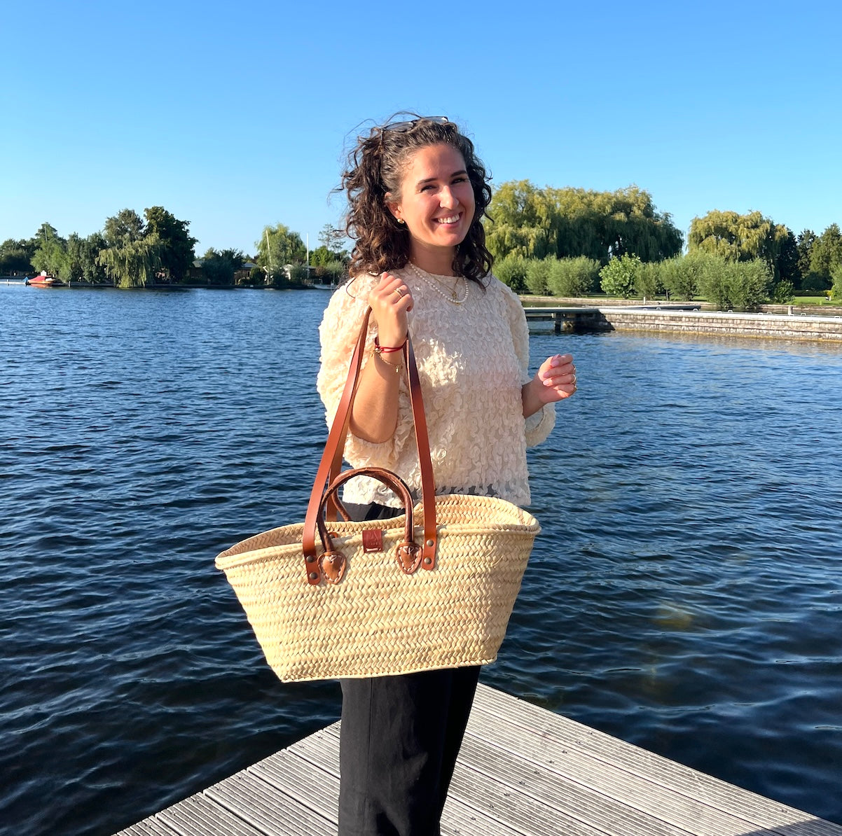 Zeer ruime rieten tas met een rechthoekig ruim model uit de Valencia collectie met handvatten en hengsels die door Sofia gedragen wordt