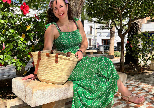 Sofia met de rieten tas met verstelbare leren hengsels op een bankje