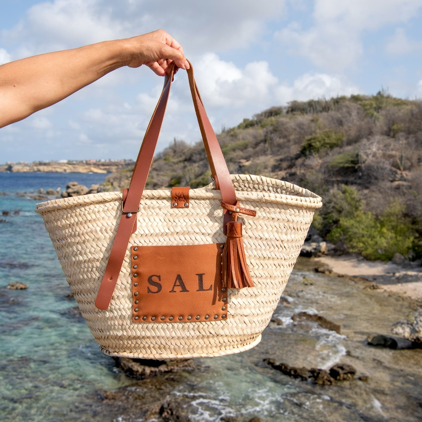 Rieten tas met verstelbare hengsels en 3 initialen aan zee op Curacao