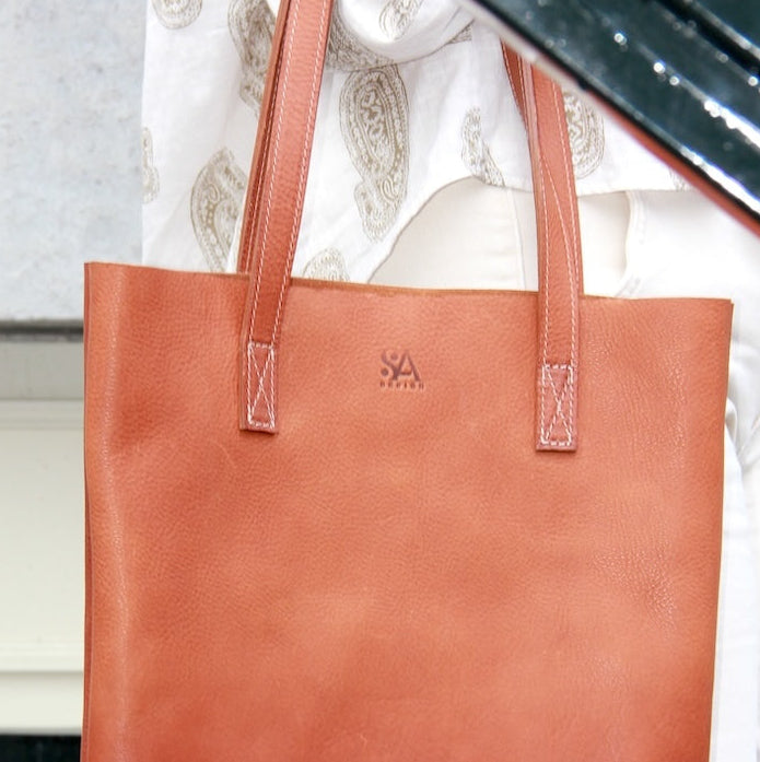 Cognac leren tote van natuurlijk gelooid leer op een trap in Amsterdam