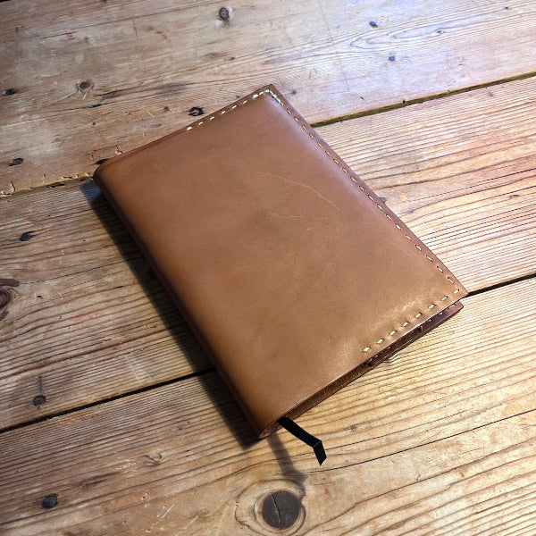 Handgemaakte leren notebook die is gemaakt in een workshop op locatie in zand met rijgsteek