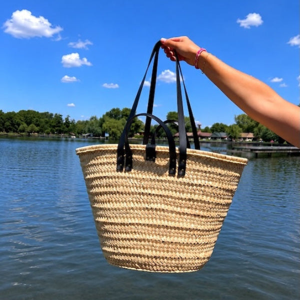 Foto boven water met de rieten strandtas medium met zwarte handvatten en hengsels
