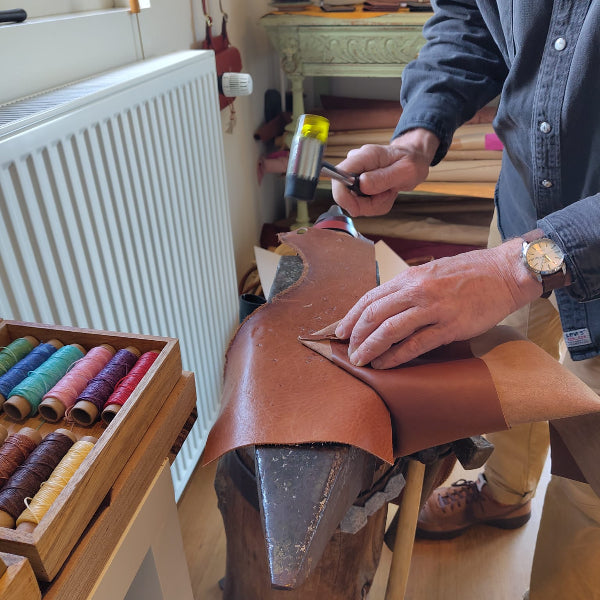Hameren van naden in workshop leren tas